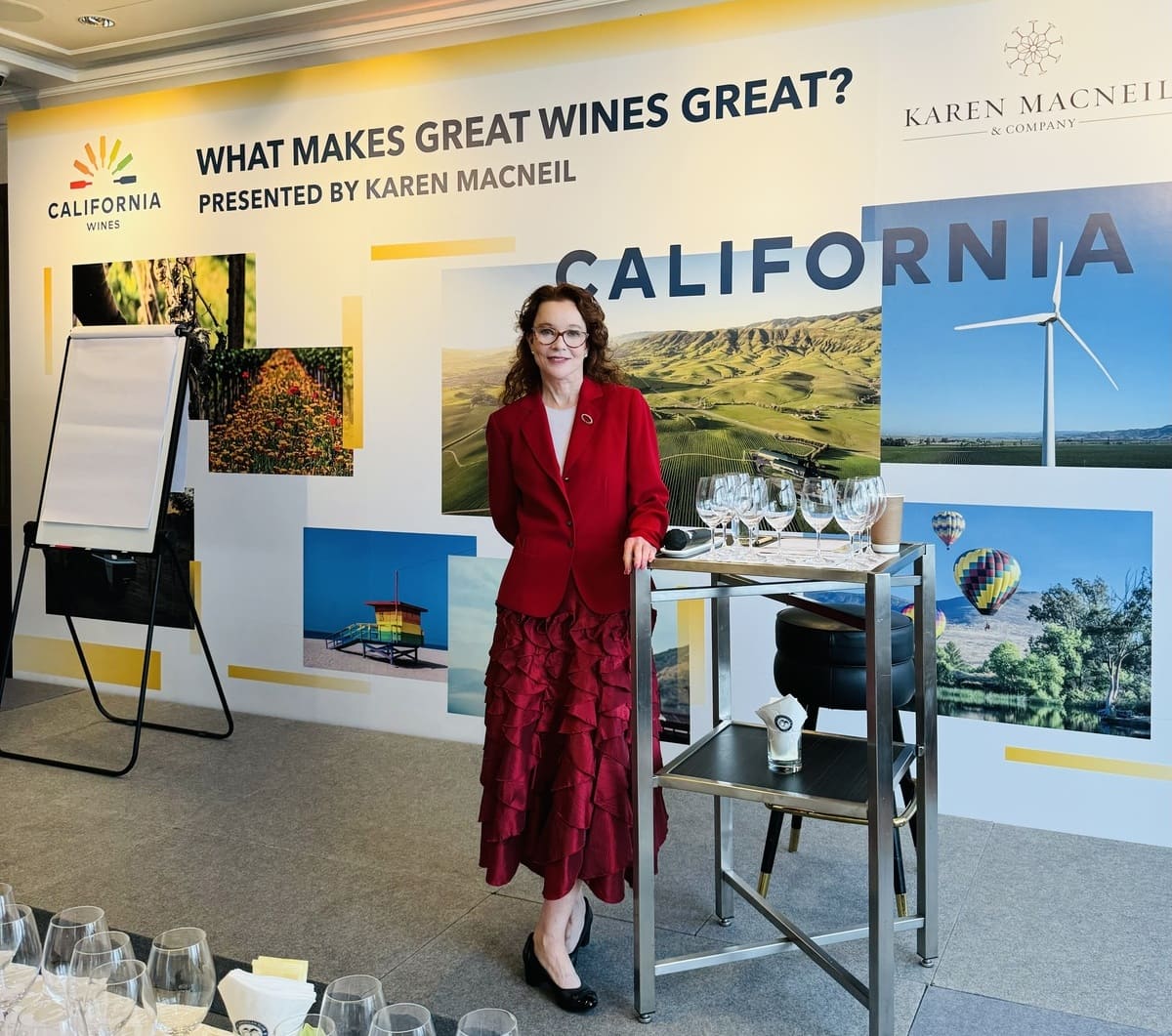 woman standing next to table of wine glasses